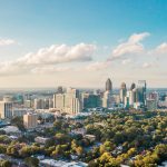 City View of Atlanta with green trees in the foreground. Bird eye perspective on a sunny day with few clouds.